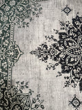 Black ornate medallion and floral pattern on a pale grey rug