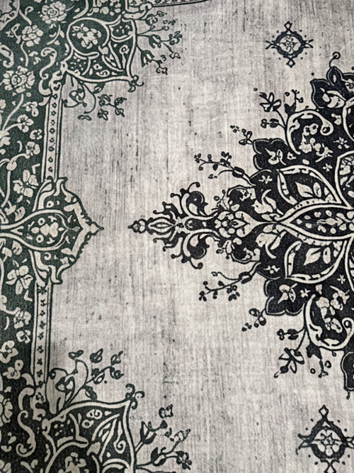 Black ornate medallion and floral pattern on a pale grey rug