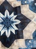 Blue and cream geometric rug with a large flower motif