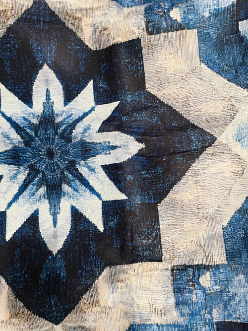 Blue and cream geometric rug with a large flower motif