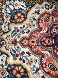 Cream rug with burgundy, navy, teal and gold floral medallion pattern