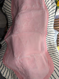 Pink mat with a wavy scalloped outline, photographed draped over a chair
