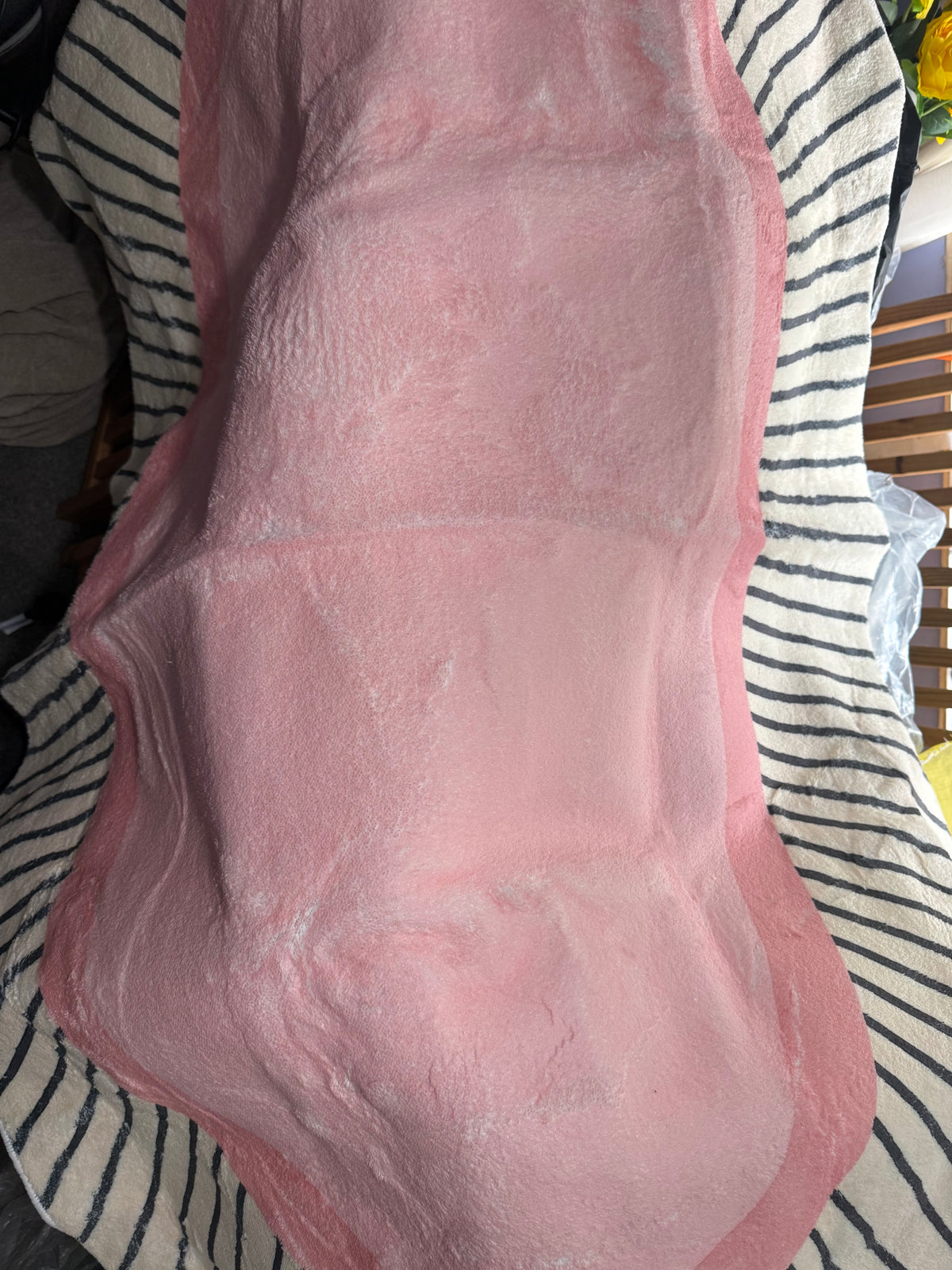 Pink mat with a wavy scalloped outline, photographed draped over a chair
