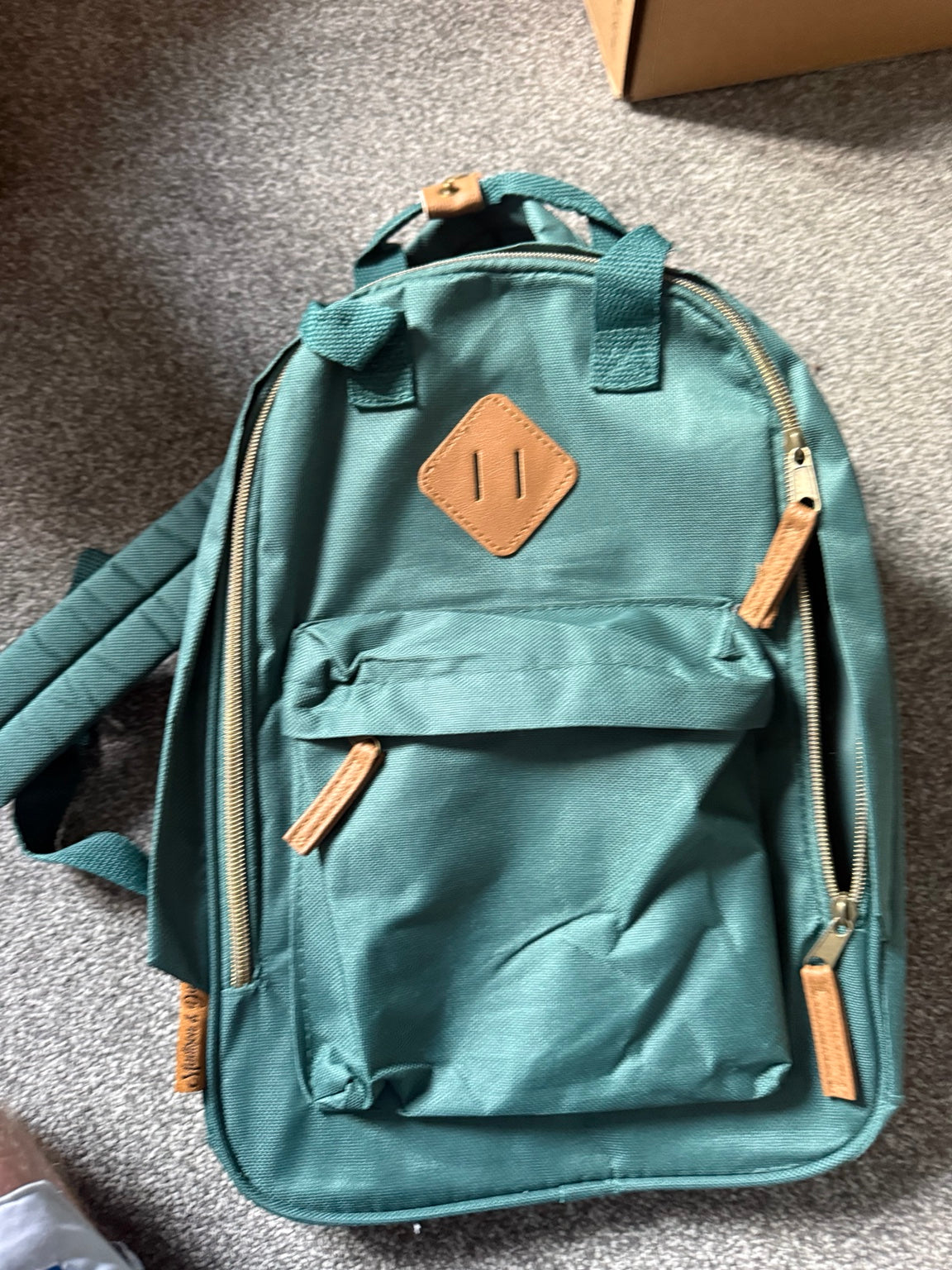 Front view of the Madison & Dakota green rucksack with tan trims