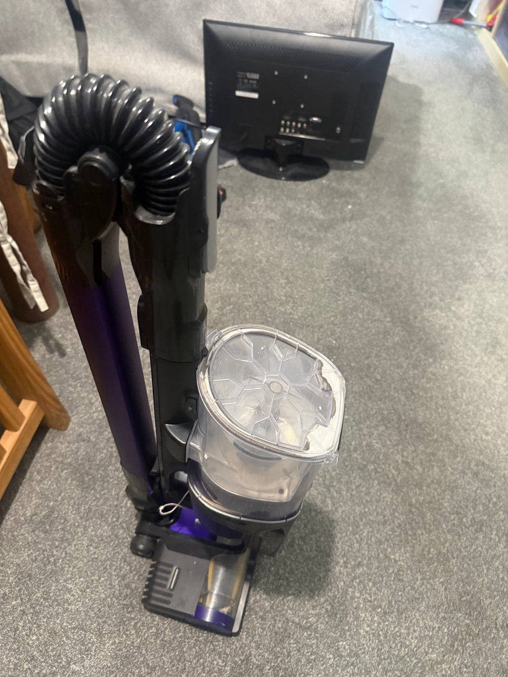 Actual pre-owned purple and dark grey Shark cordless vacuum cleaner with wand folded